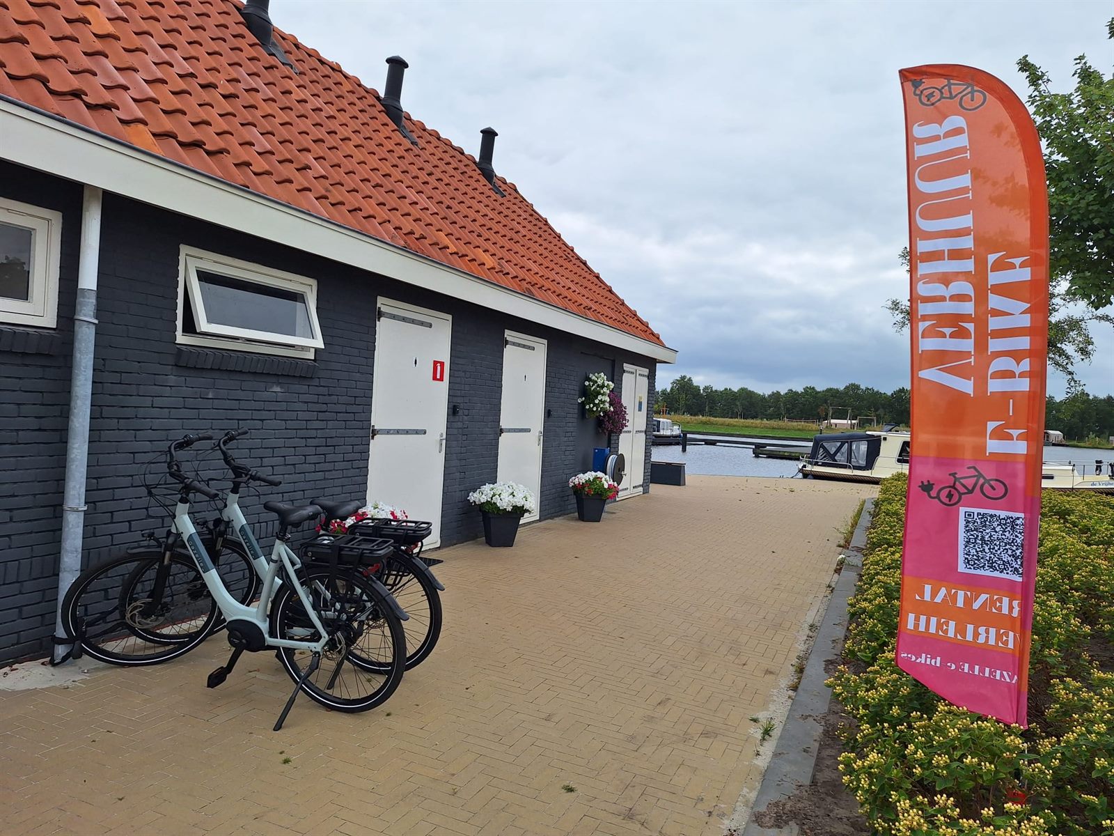 E-bikes en beachflag bij het havengebouw in Oudega (Smallingerland)